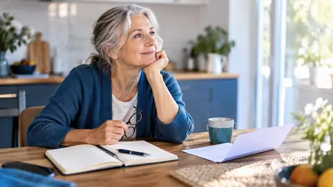 Personne de 65 ans préparant un dossier d'assurance décès à sa table