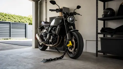 Moto stationnée dans un garage avec antivol et chaîne