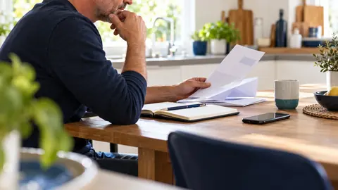 Emprunteur relisant un courrier d'assurance avant de contesté une surprime
